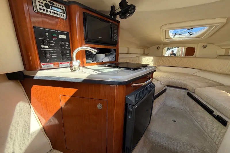 Slide: The Image of Interior of 2007 Sea Ray 240 Sundancer boat with kitchenette and seating area. - 47