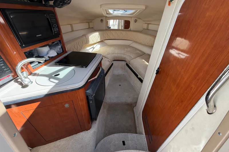 Slide: The Image of Interior of 2007 Sea Ray 240 Sundancer boat with kitchenette and seating area. - 46