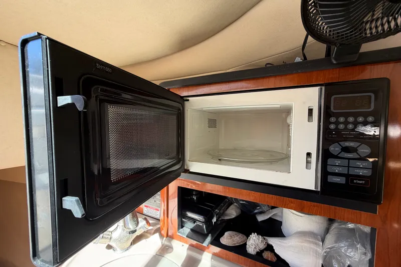 Slide: The Image of Microwave inside 2007 Sea Ray 240 Sundancer boat, with open door and control panel. - 53
