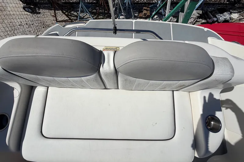 Slide: The Image of 2007 Sea Ray 240 Sundancer boat seating area with gray cushions and white upholstery. - 86
