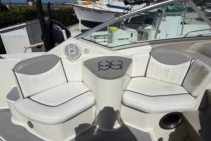 Slide: The Image of 2007 Sea Ray 240 Sundancer boat interior with white seating and cup holders. - 24