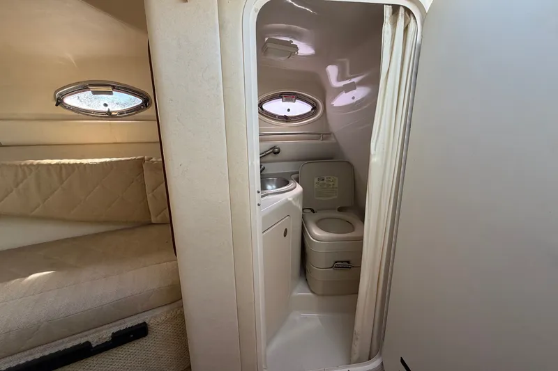 Slide: The Image of 2007 Sea Ray 240 Sundancer cabin interior with compact bathroom and cozy seating area. - 69