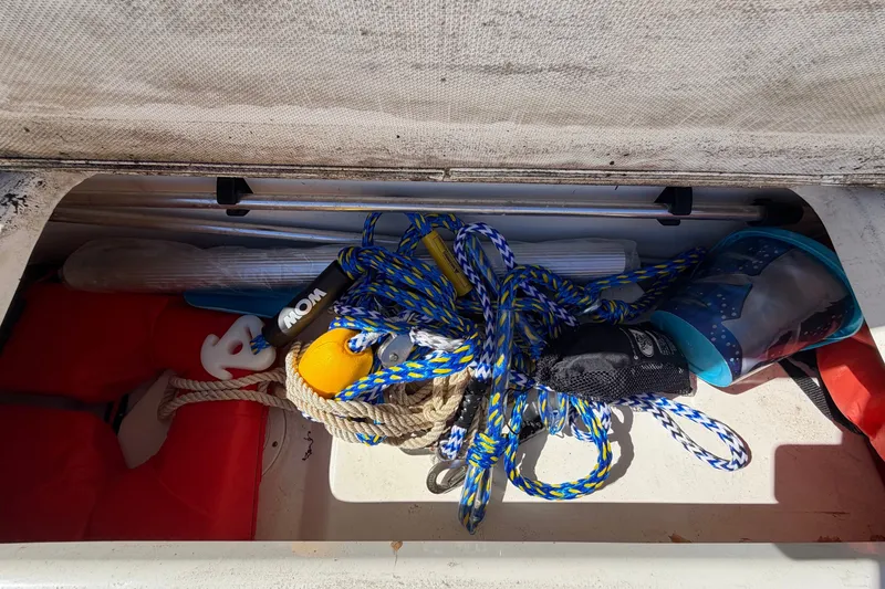 Slide: The Image of Storage compartment of a 2007 Sea Ray 240 Sundancer with ropes and equipment. - 85