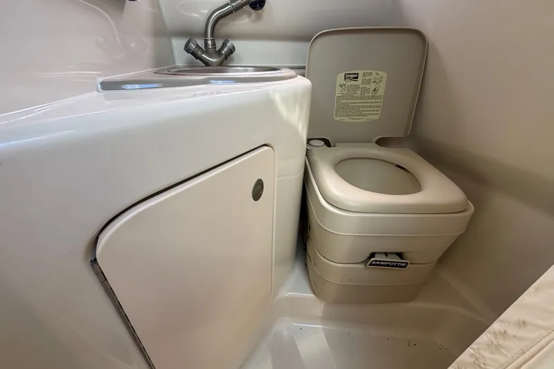 Slide: The Image of Compact bathroom in 2007 Sea Ray 240 Sundancer boat with sink and portable toilet. - 71