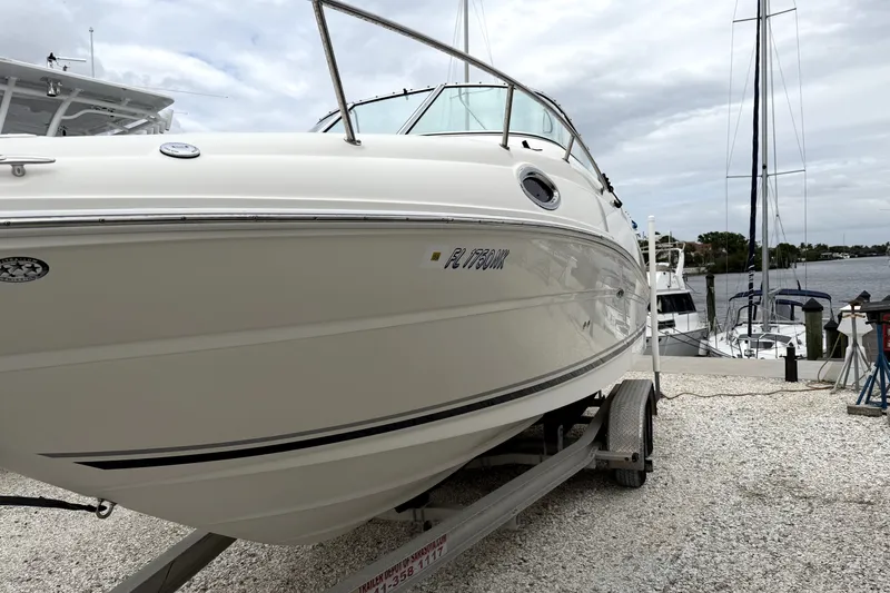 Slide: The Image of 2007 Sea Ray 240 Sundancer boat on trailer by waterfront, overcast sky. - 4