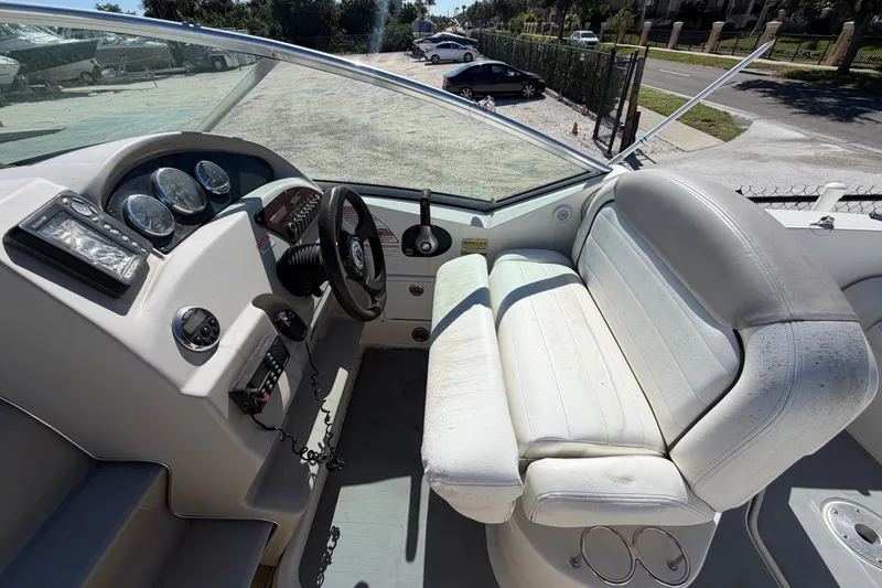 Slide: The Image of 2007 Sea Ray 240 Sundancer boat interior with steering wheel and white seating. - 26