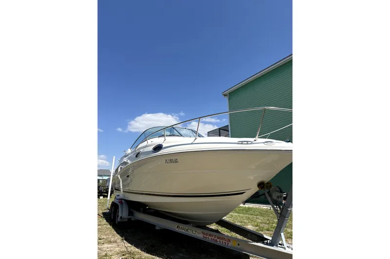 Slide: The Image of 2007 Sea Ray 240 Sundancer boat on trailer under clear blue sky. - 3