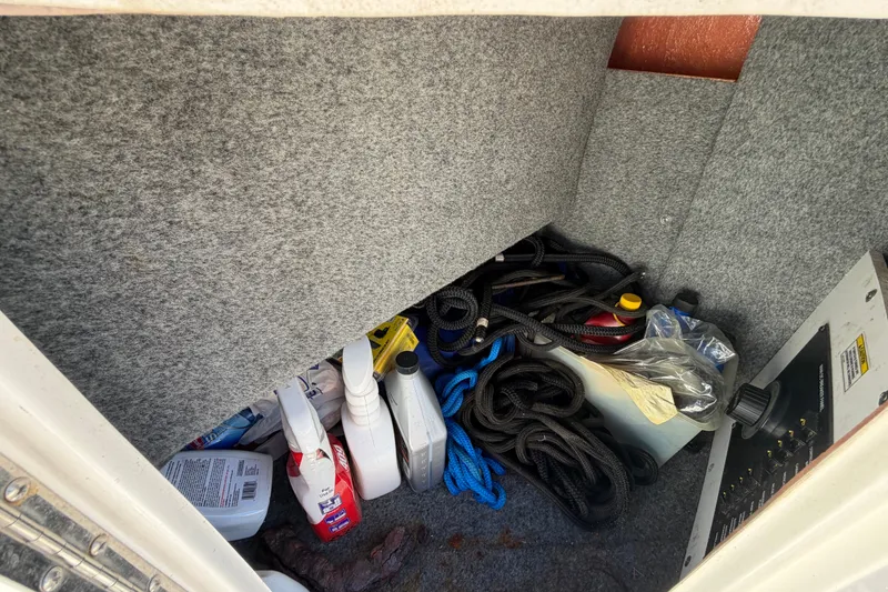 Slide: The Image of Storage compartment of a 2007 Sea Ray 240 Sundancer with ropes and cleaning supplies. - 21