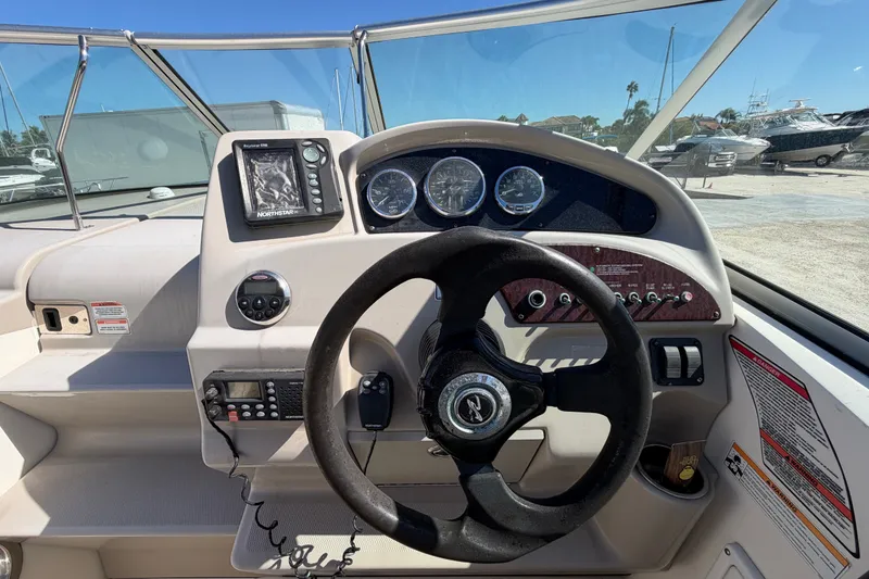 Slide: The Image of 2007 Sea Ray 240 Sundancer boat dashboard with steering wheel and navigation instruments. - 28
