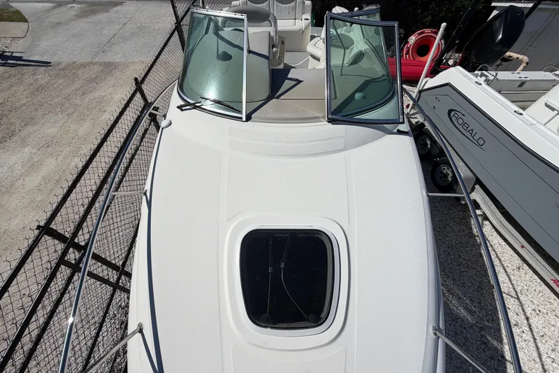 Slide: The Image of 2007 Sea Ray 240 Sundancer boat with open windshield and hatch, docked beside another boat. - 42