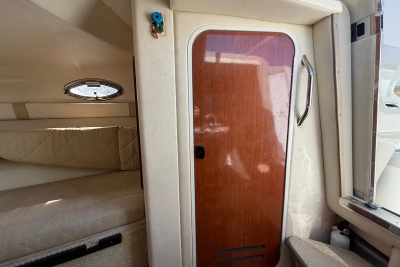 Slide: The Image of Interior cabin of 2007 Sea Ray 240 Sundancer with wooden door and porthole window. - 68