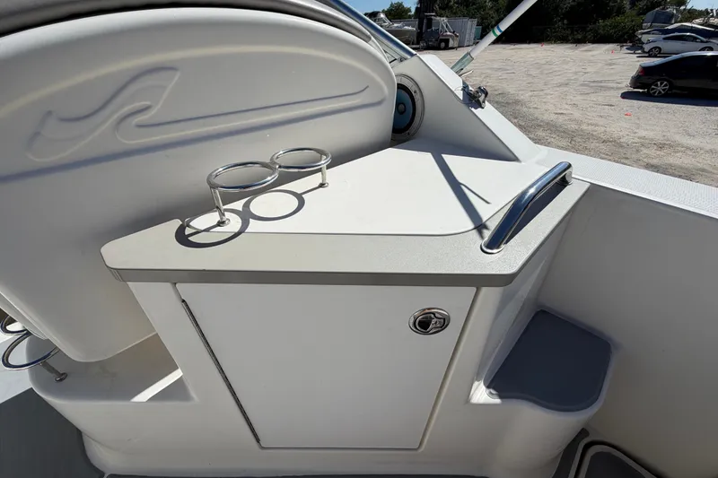 Slide: The Image of 2007 Sea Ray 240 Sundancer boat interior with cup holders and storage compartment. - 19