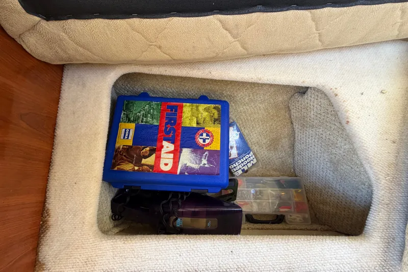 Slide: The Image of First aid kit and tools stored in a 2007 Sea Ray 240 Sundancer compartment. - 59