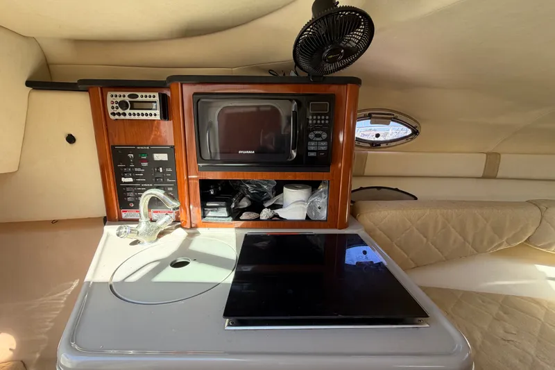 Slide: The Image of Interior of 2007 Sea Ray 240 Sundancer with kitchenette, microwave, and seating area. - 52