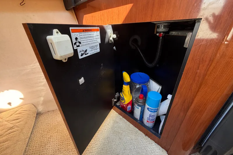 Slide: The Image of Open cabinet on 2007 Sea Ray 240 Sundancer with cleaning supplies inside. - 48