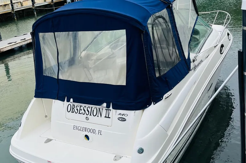 Slide: The Image of 2007 Sea Ray 240 Sundancer boat docked, featuring blue canopy and "Obsession IV" name. - 6