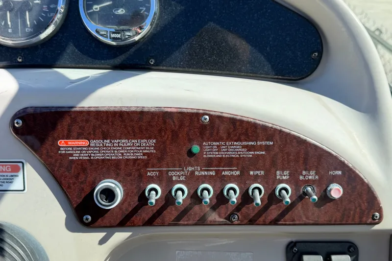 Slide: The Image of Control panel of a 2007 Sea Ray 240 Sundancer boat with switches and warning labels. - 34