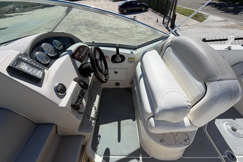 Slide: The Image of 2007 Sea Ray 240 Sundancer cockpit with steering wheel, gauges, and white seating. - 27