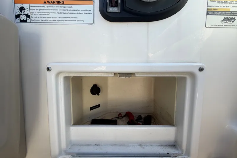 Slide: The Image of Storage compartment on a 2007 Sea Ray 240 Sundancer boat with warning labels. - 36