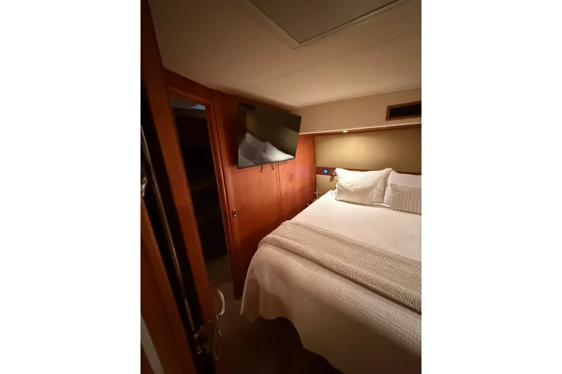 Slide: The Image of Interior cabin of 2010 Maritimo 500 Offshore Convertible yacht, featuring a cozy bed and TV. - 26