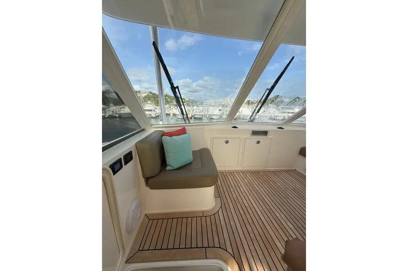 Slide: The Image of Interior of 2010 Maritimo 500 Offshore Convertible yacht with cushioned seating and wooden flooring. - 20