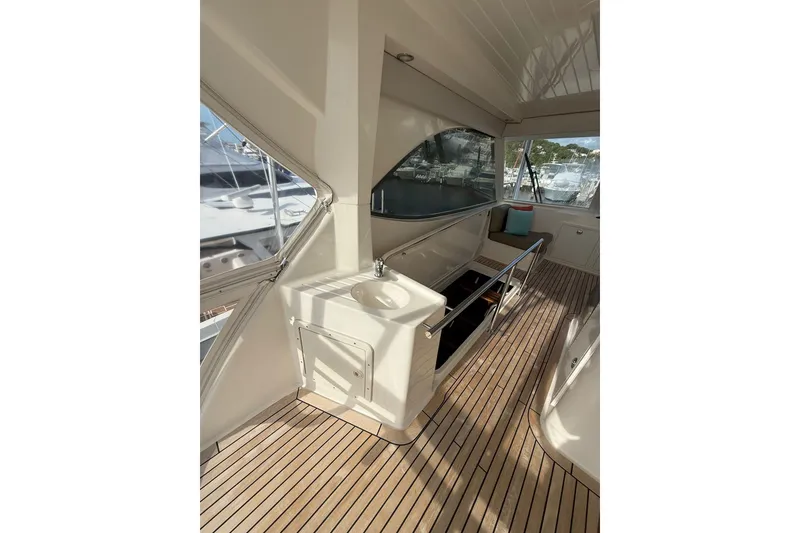 Slide: The Image of 2010 Maritimo 500 Offshore Convertible yacht interior with teak flooring and seating area. - 18