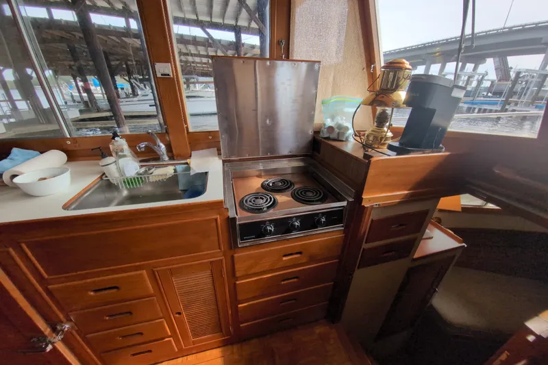 Slide: The Image of Galley of 1990 Grand Banks 36 Classic yacht with stove, sink, and wooden cabinetry. - 35