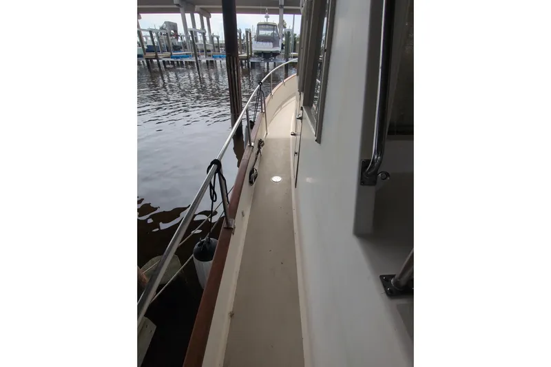 Slide: The Image of Side deck view of a 1990 Grand Banks 36 Classic yacht docked at a marina. - 9
