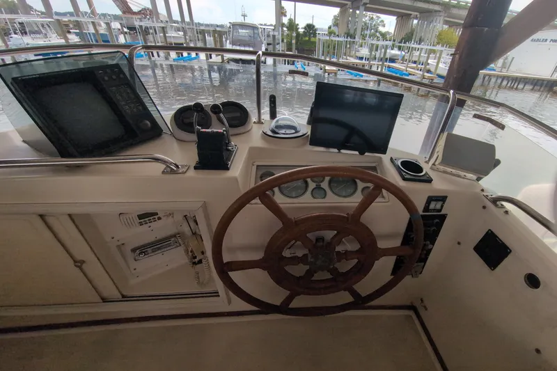 Slide: The Image of Helm of 1990 Grand Banks 36 Classic yacht with wooden wheel and navigation equipment. - 28