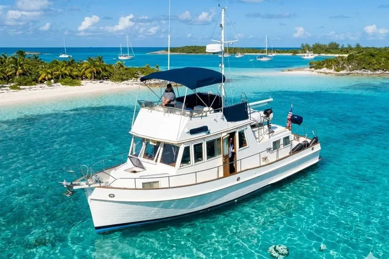 Slide: The Image of 1990 Grand Banks 36 Classic yacht in turquoise waters near tropical island. - 0