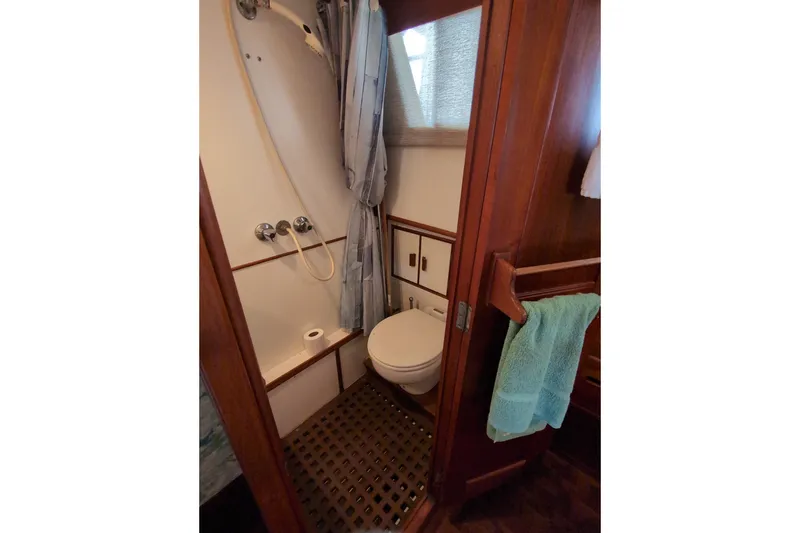 Slide: The Image of 1990 Grand Banks 36 Classic yacht bathroom with shower, toilet, and wooden accents. - 52