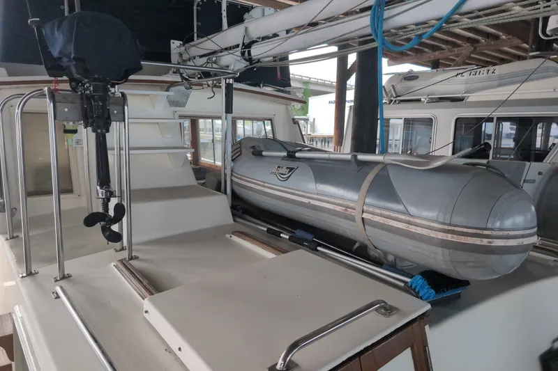 Slide: The Image of 1990 Grand Banks 36 Classic with inflatable dinghy on deck, docked in a marina. - 22