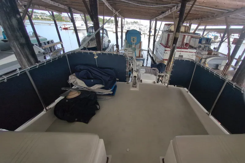 Slide: The Image of 1990 Grand Banks 36 Classic yacht docked in a covered marina, with visible deck and seating. - 26