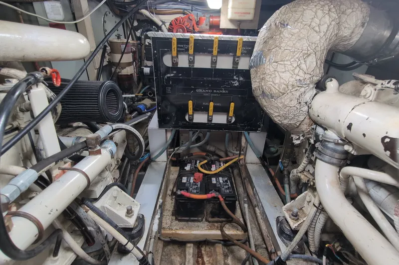 Slide: The Image of Engine room of a 1990 Grand Banks 36 Classic boat, showcasing mechanical components and wiring. - 58