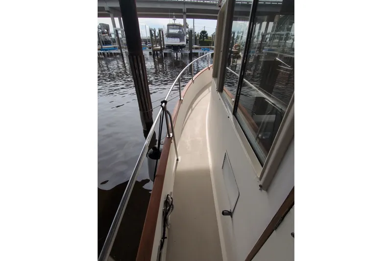 Slide: The Image of Side deck view of a 1990 Grand Banks 36 Classic yacht docked at a marina. - 11