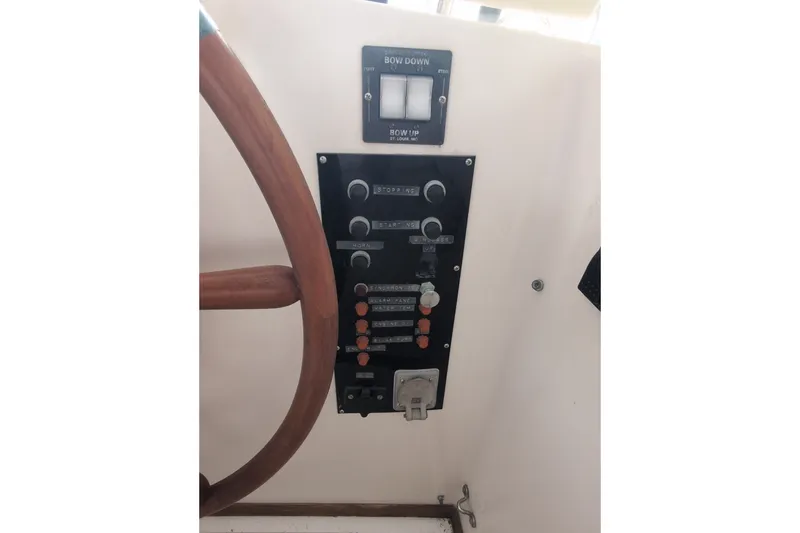 Slide: The Image of Control panel of a 1990 Grand Banks 36 Classic boat with wooden steering wheel. - 30
