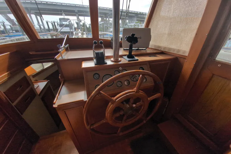 Slide: The Image of Helm of 1990 Grand Banks 36 Classic yacht with wooden wheel and navigation instruments. - 37