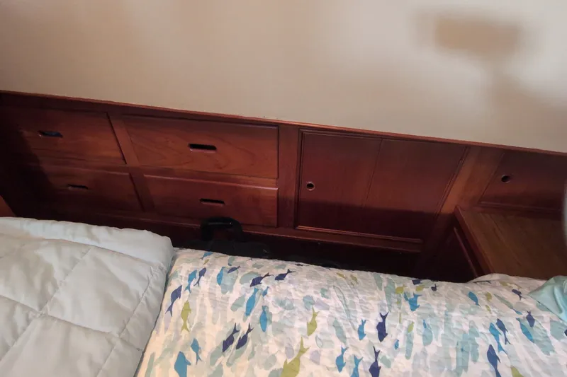 Slide: The Image of Interior of 1990 Grand Banks 36 Classic with wooden drawers and patterned bedding. - 49