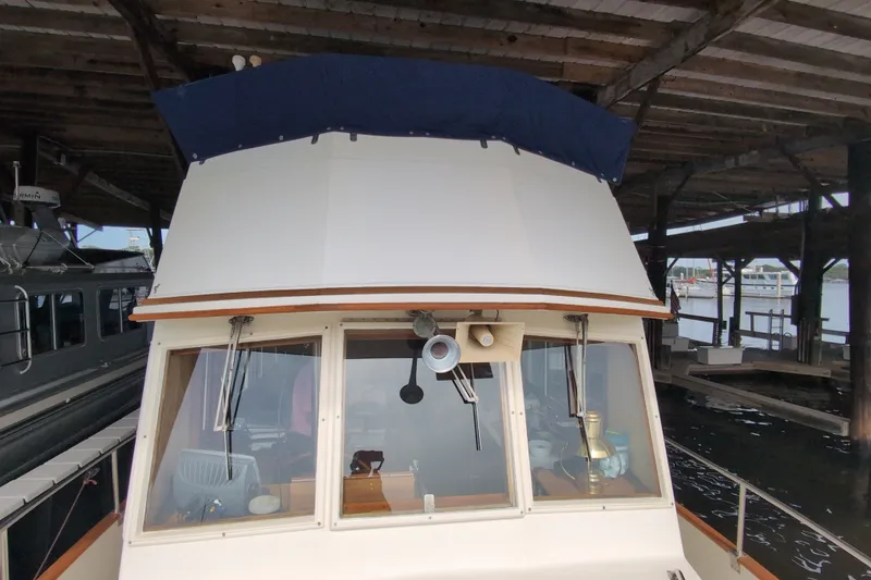 Slide: The Image of 1990 Grand Banks 36 Classic boat docked under a wooden shelter. - 16