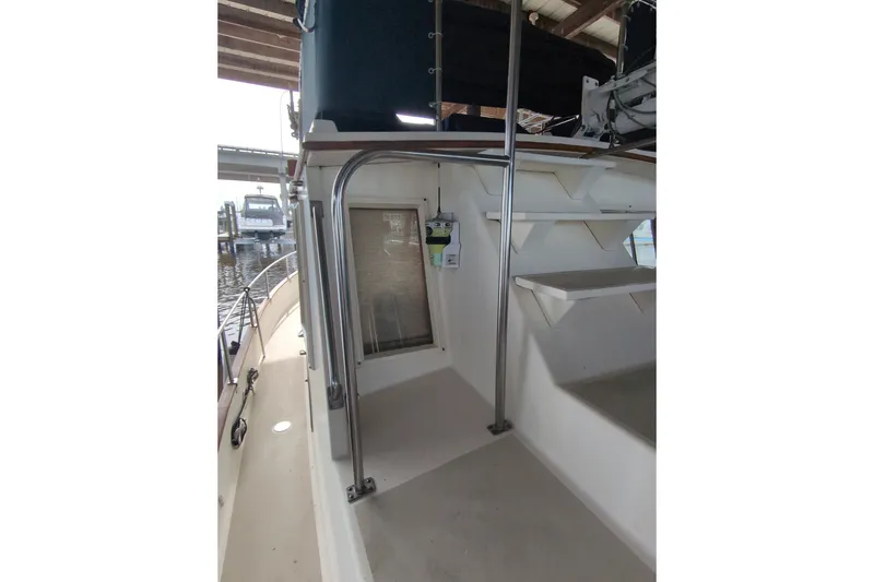 Slide: The Image of 1990 Grand Banks 36 Classic boat deck with railing and steps under covered dock. - 25