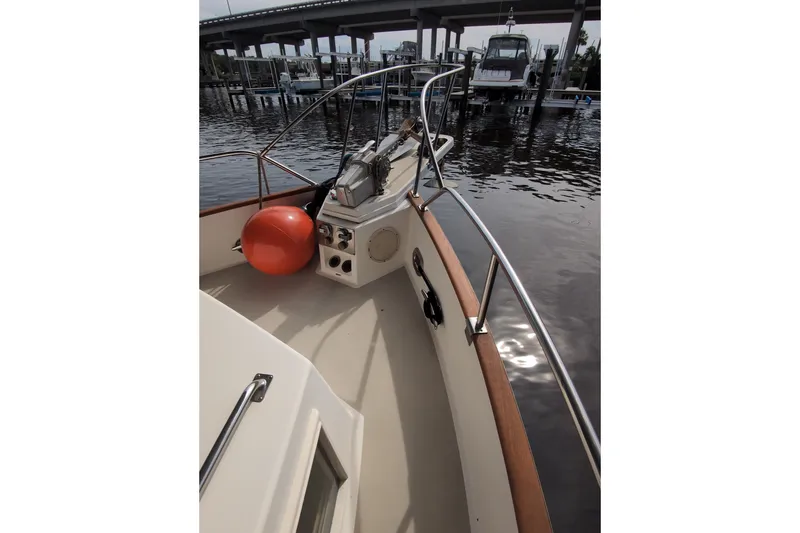 Slide: The Image of Bow view of 1990 Grand Banks 36 Classic yacht docked near a bridge. - 17