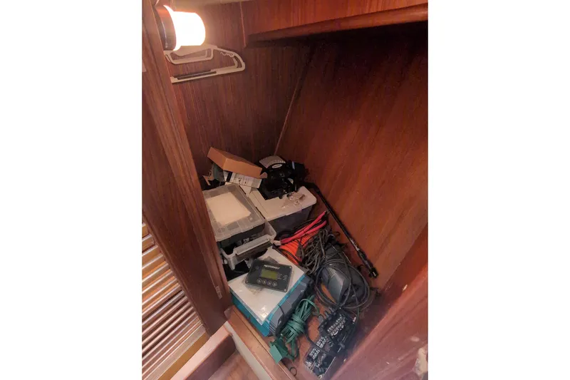Slide: The Image of Storage compartment in a 1990 Grand Banks 36 Classic boat with various equipment and cables. - 43