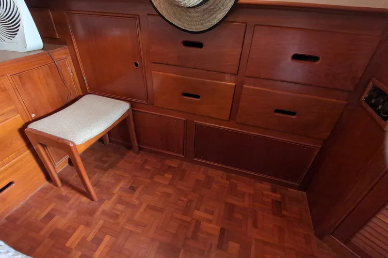 Slide: The Image of Wooden interior of 1990 Grand Banks 36 Classic with drawers and a cushioned stool. - 48