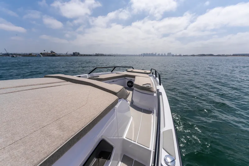 Slide: The Image of 2027 Axopar 38 Cross Cabin cruising on open water under a partly cloudy sky. - 16