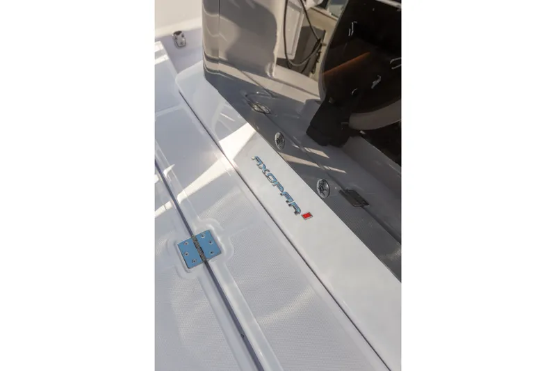 Slide: The Image of 2027 Axopar 38 Cross Cabin boat deck with logo and sleek design details. - 21