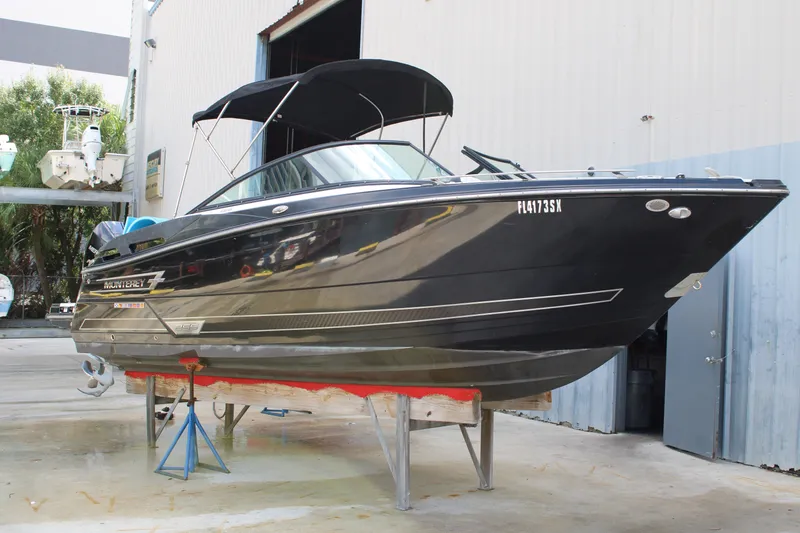 Slide: The Image of 2021 Monterey 255SS Super Sport boat on stands in a marina setting. - 2