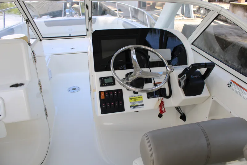 Slide: The Image of 2021 World Cat 255 DC boat cockpit with steering wheel and control panel. - 22