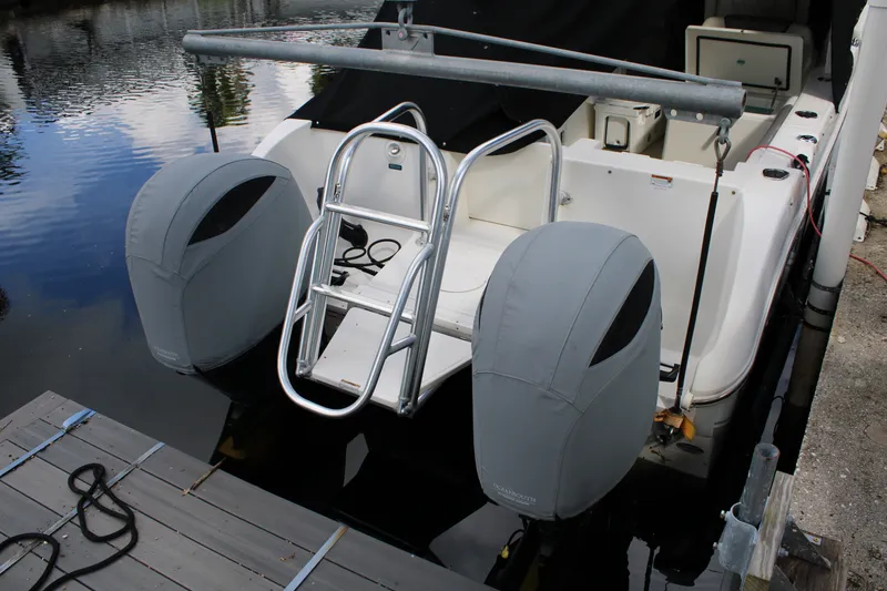 Slide: The Image of 2021 World Cat 255 DC boat with covered engines and swim ladder at dock. - 32