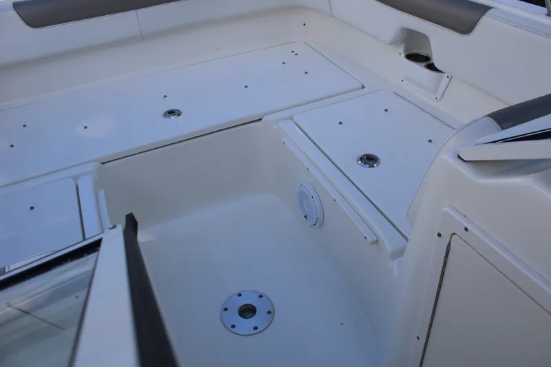 Slide: The Image of 2021 World Cat 255 DC boat interior with storage compartments and seating area. - 18
