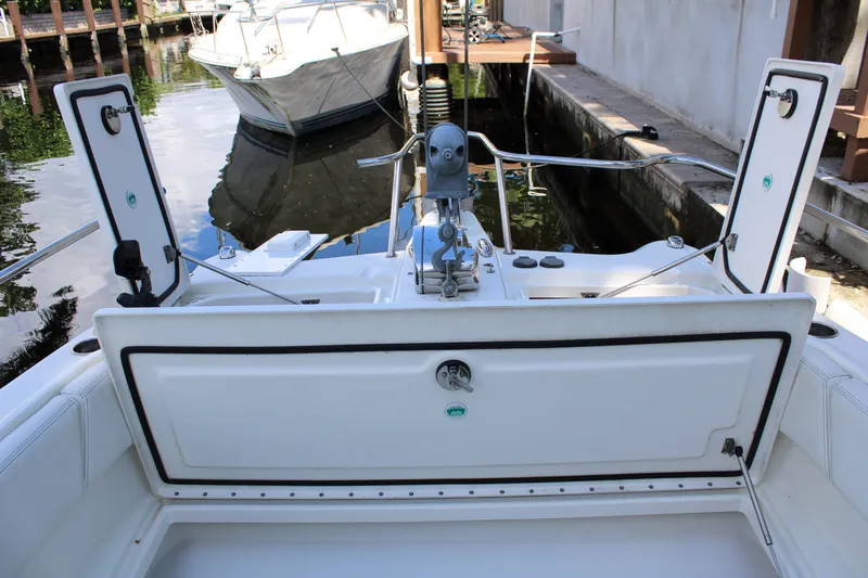 Slide: The Image of 2021 World Cat 255 DC boat interior with open storage compartments at dock. - 13